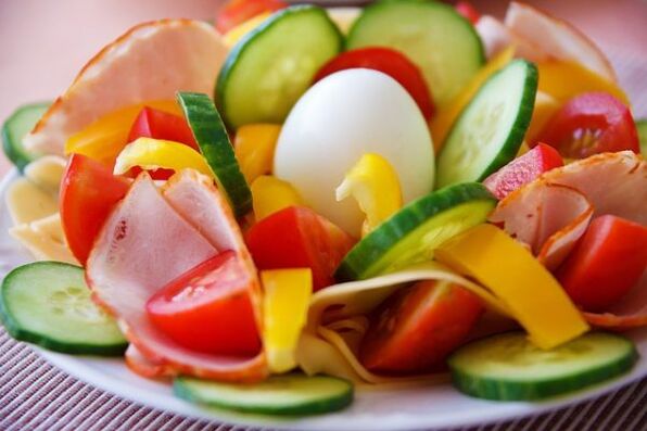 سلطة الخضار في قائمة النظام الغذائي مع البيض والبرتقال لإنقاص الوزن